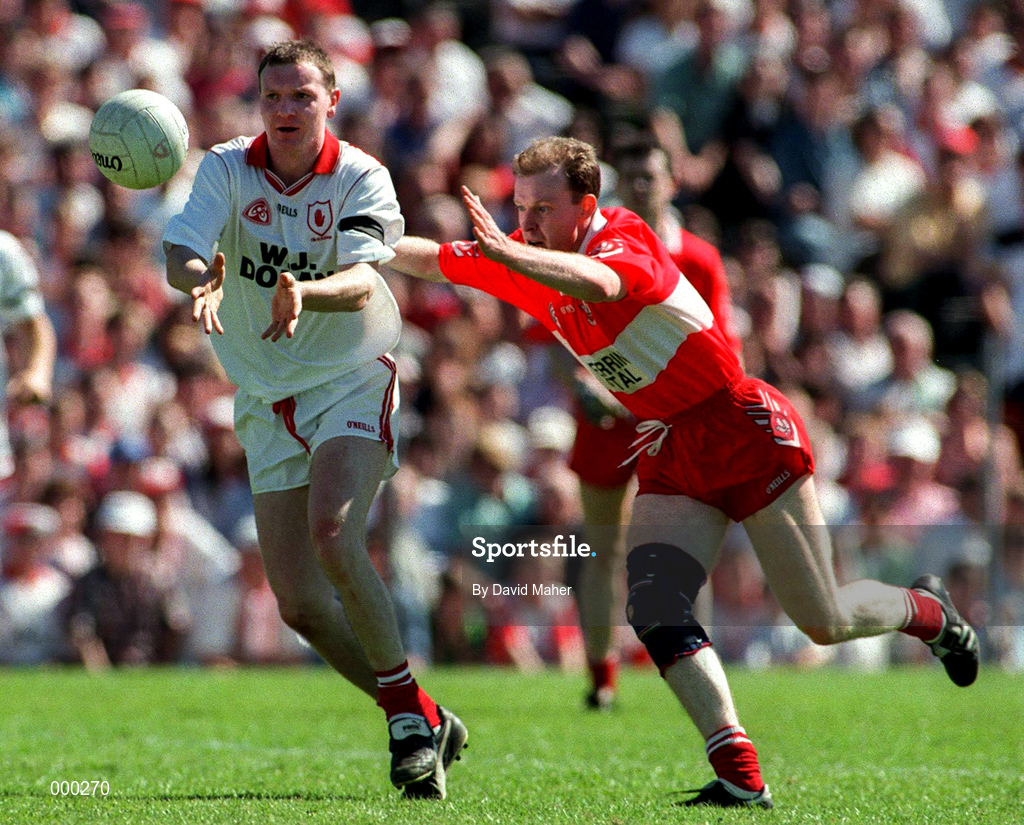 29 June 1997; Chris Lawn of Tyrone gets a pass away despite the attentions of Seamus Downey of Derry during the Ulster GAA Football Senior Championship Semi-Final match between Tyrone and Derry at St. Tiernach's Park in Clones, Monaghan. Photo by David Maher/Sportsfile