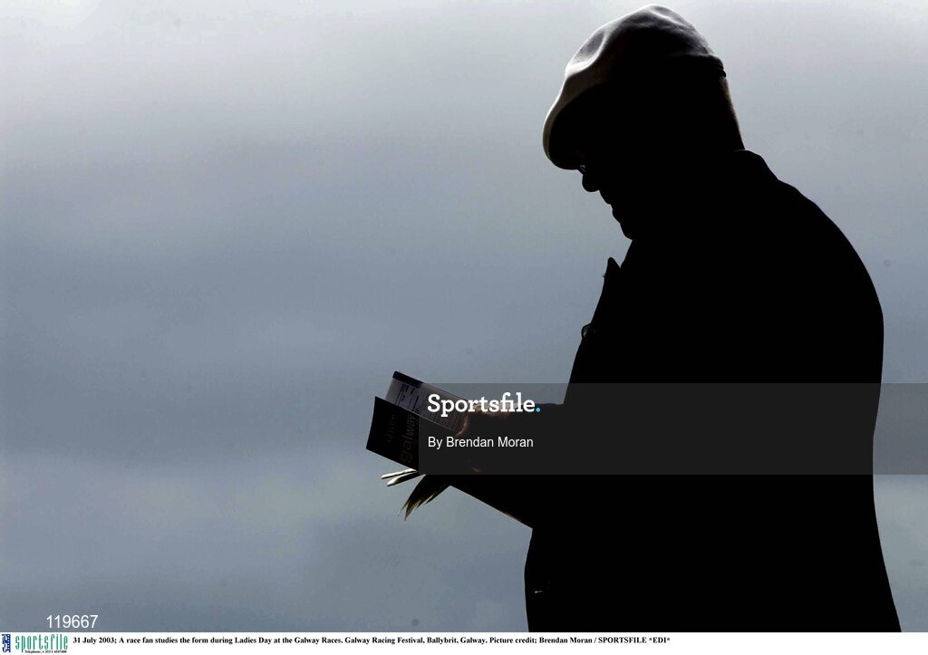 31 July 2003; A race fan studies the form during Ladies Day at the Galway Races. Galway Racing Festival, Ballybrit, Galway. Picture credit; Brendan Moran / SPORTSFILE *EDI*