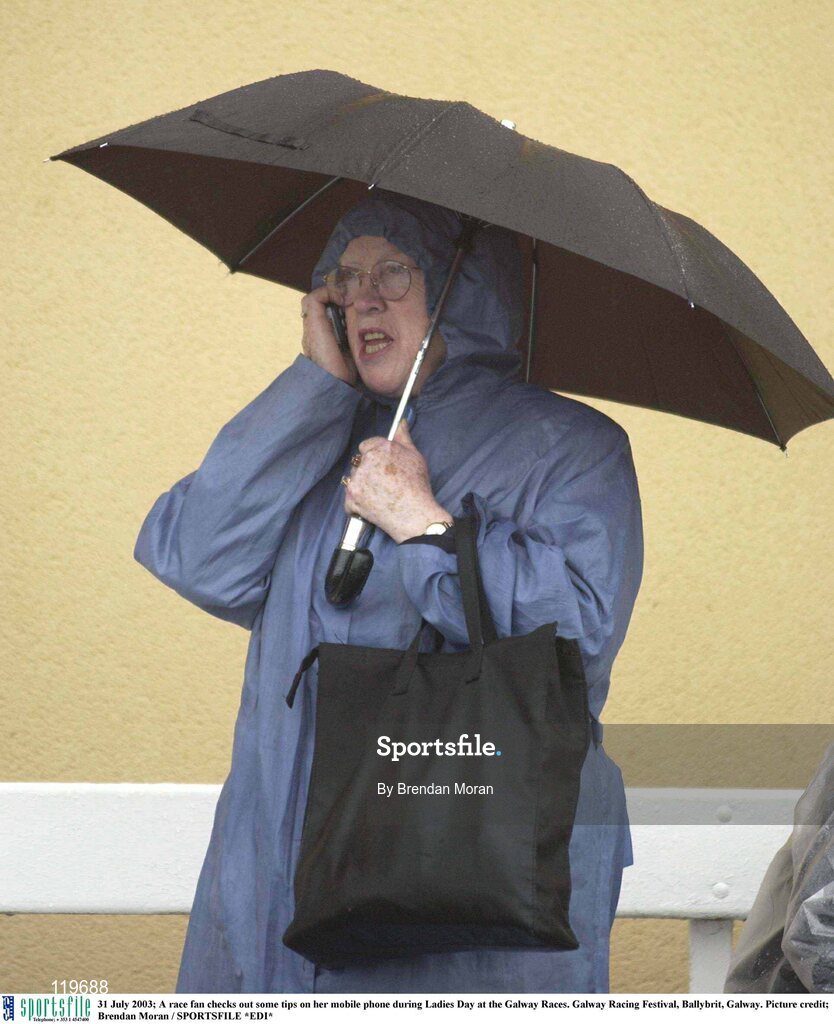 31 July 2003; A race fan checks out some tips on her mobile phone during Ladies Day at the Galway Races. Galway Racing Festival, Ballybrit, Galway. Picture credit; Brendan Moran / SPORTSFILE *EDI*