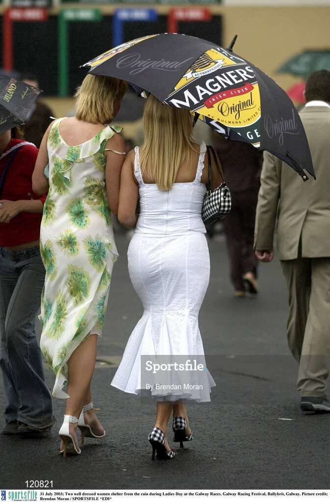 31 July 2003; Two well dressed women shelter from the rain during Ladies Day at the Galway Races. Galway Racing Festival, Ballybrit, Galway. Picture credit; Brendan Moran / SPORTSFILE *EDI*