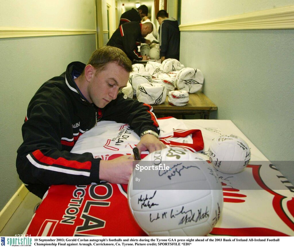10 September 2003; Gerald Cavlan autograph's footballs and shirts during the Tyrone GAA press night ahead of the 2003 Bank of Ireland All-Ireland Football Championship Final against Armagh. Carrickmore, Co. Tyrone. Picture credit; SPORTSFILE *EDI*