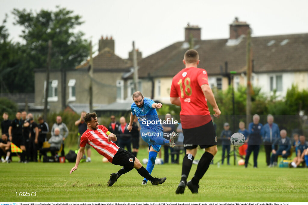 25 August 2019; Alan McGreal of Crumlin United has a shot on goal despite the tackle from Michael McLoughlin of Lucan United during the Extra.ie FAI Cup Second Round match between Crumlin United and Lucan United at CBS Captain's Road in Crumlin, Dublin. Photo by David Fitzgerald/Sportsfile