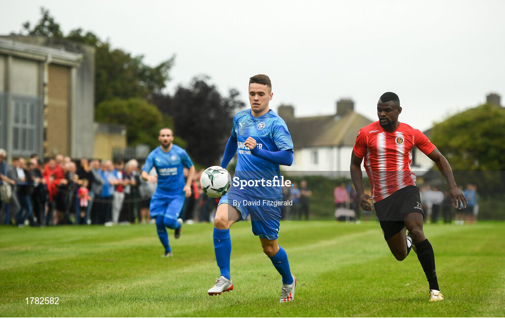 25 August 2019; Liam Brady of Crumlin United in action against Tamena Dinamunenga of Lucan United during the Extra.ie FAI Cup Second Round match between Crumlin United and Lucan United at CBS Captain's Road in Crumlin, Dublin. Photo by David Fitzgerald/Sportsfile