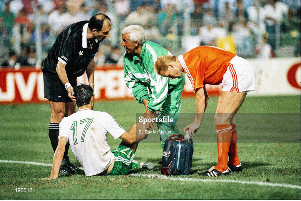 21 June 1990; Referee Michel Vautrot speaks to Republic of Ireland physio Mick Byrne as he gives assistance to Niall Quinn during the FIFA World Cup 1990 Group F match between Republic of Ireland and Netherlands at Stadio La Favorita in Palermo, Italy. Photo by Ray McManus/Sportsfile