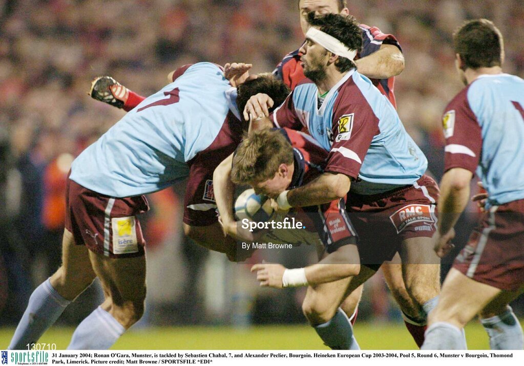 31 January 2004; Ronan O'Gara, Munster, is tackled by Sebastien Chabal, 7, and Alexander Peclier, Bourgoin. Heineken European Cup 2003-2004, Pool 5, Round 6, Munster v Bourgoin, Thomond Park, Limerick. Picture credit; Matt Browne / SPORTSFILE *EDI*