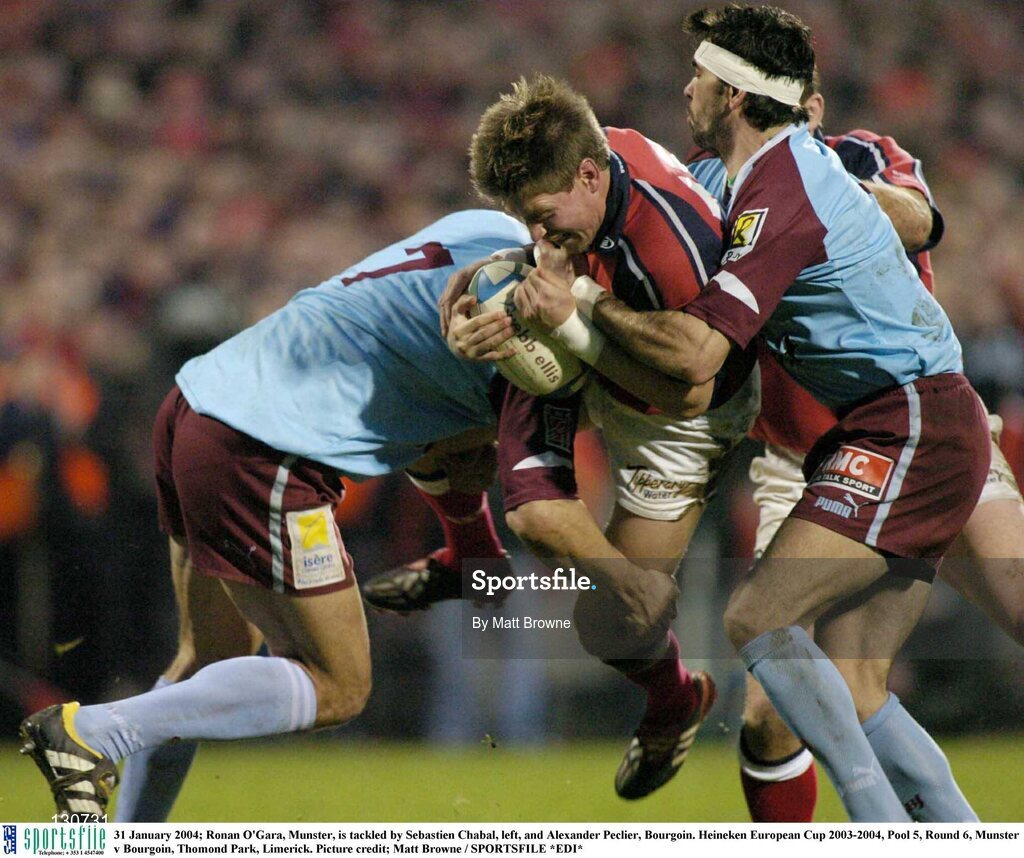 31 January 2004; Ronan O'Gara, Munster, is tackled by Sebastien Chabal, left, and Alexander Peclier, Bourgoin. Heineken European Cup 2003-2004, Pool 5, Round 6, Munster v Bourgoin, Thomond Park, Limerick. Picture credit; Matt Browne / SPORTSFILE *EDI*