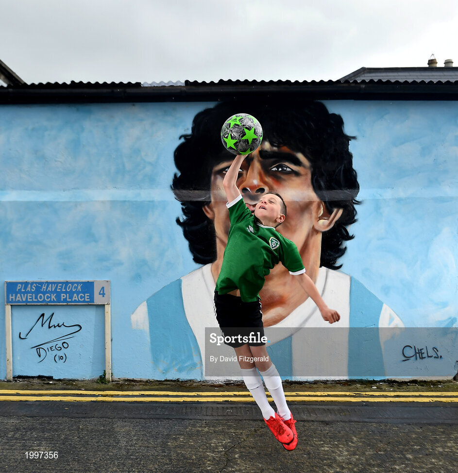 12 April 2021; Local resident Johnny Figo Murphy, age 9, from Dublin imitates the famous 'Hand of God' in front of a mural by Dublin artist Chelsea Jacobs depicting the late Argentine footballer Diego Maradona at Havelock Square in Dublin. Photo by David Fitzgerald/Sportsfile