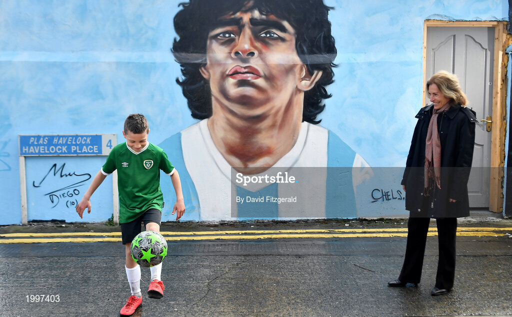 12 April 2021; Her Excellency Mrs. S. Moira Wilkinson, Argentine Ambassador to the Republic of Ireland, watches local resident Johnny Figo Murphy, aged 9, from Sandymount Dublin showing off his skills in front of a mural by Dublin artist Chelsea Jacobs depicting the late Argentine footballer Diego Maradona at Havelock Square in Dublin. Photo by David Fitzgerald/Sportsfile