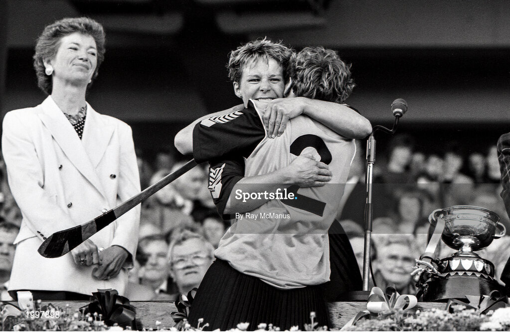 22 September 1991; Kilkenny captain Angela Downey celebrates with team-mate Biddy O'Sullivan, 2, in the company of President Mary Robinson after the All Ireland Camogie Final match between Kilkenny and Cork at Croke Park in Dublin. Photo by Ray McManus/Sportsfile