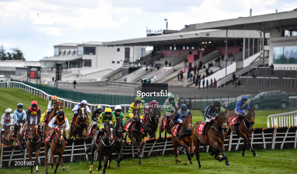 27 April 2021; Runners and riders jump the second fence in front of an empty grandstand during the Have The Conversation Say Yes To Organ Donation Novice Handicap Hurdle during day one of the Punchestown Festival at Punchestown Racecourse in Kildare. Photo by David Fitzgerald/Sportsfile