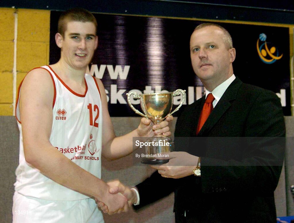 23 March 2004; St Pat's captain Damien Power is presented with the cup by Martin Hehir, Schools Development Officer of Basketball Ireland. All-Ireland Schoolboys Basketball League, U16 'C'  Final, Dunshaughlin Community College, Meath v St Pat's, Shannon, Co. Clare, ESB Arena, Tallaght, Dublin. Picture credit; Brendan Moran / SPORTSFILE *EDI*