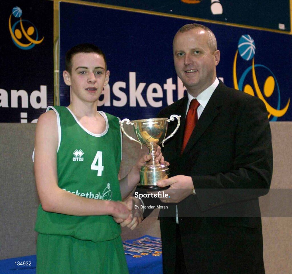 23 March 2004; Ard Scoil Ris captain Stuart Hehir is presented with the cup by Martin Hehir, Schools Development Officer of Basketball Ireland. All-Ireland Schoolboys Basketball League, U16 'B' Final, St Nathy's Co. Roscommon v Ard Scoil Ris, Limerick, ESB Arena, Tallaght, Dublin. Picture credit; Brendan Moran / SPORTSFILE *EDI*