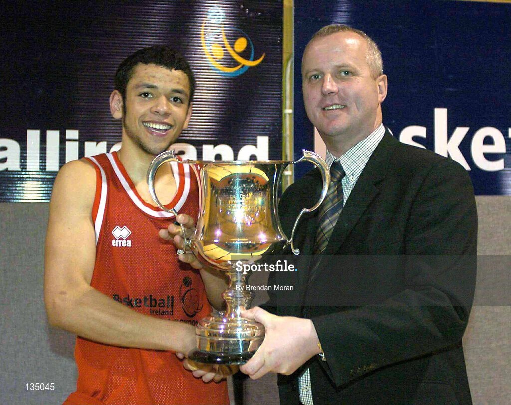 24 March 2004: St. Fintan's captain Isaac Westbrooks is presented with the cup by Martin Hehir, Schools Development Officer of Basketball Ireland. All-Ireland Schoolboys Basketball League, U19 'A'  Final, St FIntan's, Sutton, Dublin v North Monastery, Cork, ESB Arena, Tallaght, Dublin. Picture credit; Brendan Moran / SPORTSFILE *EDI*