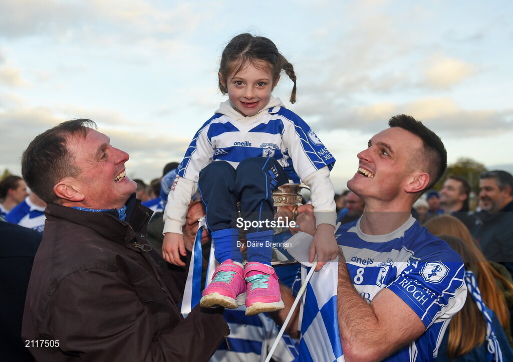 7 November 2021; Isla Doyle gets lifted in the cup after the game, by her grandad Niall O'Connor, who was centre back on the last Naas team to win the championship in 1990, and her dad Eoin Doyle of Naas after the Kildare County Senior Club Football Championship Final match between Naas and Sarsfields at St Conleth's Park in Newbridge, Kildare. Photo by Daire Brennan/Sportsfile