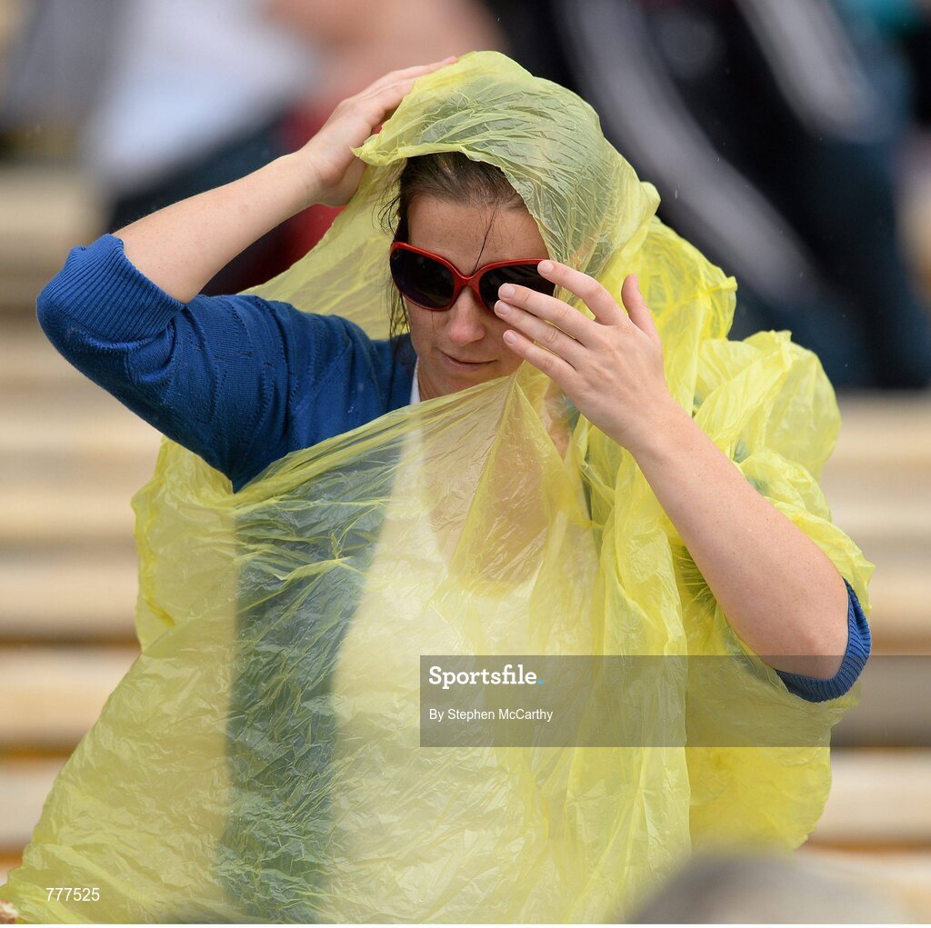 28 July 2013; A supporter attempts to shield from a shower of rain. GAA Hurling All-Ireland Senior Championship, Quarter-Final, Galway v Clare, Semple Stadium, Thurles, Co. Tipperary. Picture credit: Stephen McCarthy / SPORTSFILE
