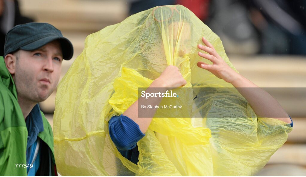 28 July 2013; A supporter attempts to shield herself from a shower of rain. GAA Hurling All-Ireland Senior Championship, Quarter-Final, Galway v Clare, Semple Stadium, Thurles, Co. Tipperary. Picture credit: Stephen McCarthy / SPORTSFILE