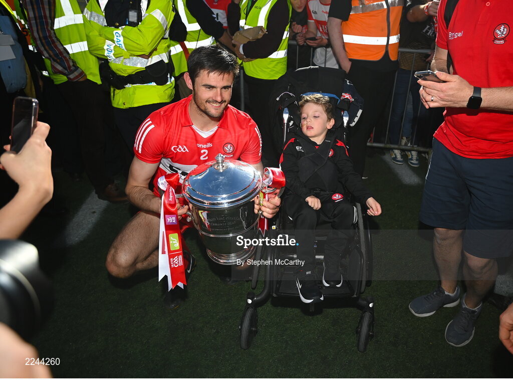 29 May 2022; Derry captain Christopher McKaigue celebrates Derry supporters Jack Henry and the Anglo Celt Cup after the Ulster GAA Football Senior Championship Final between Derry and Donegal at St Tiernach's Park in Clones, Monaghan. Photo by Stephen McCarthy/Sportsfile