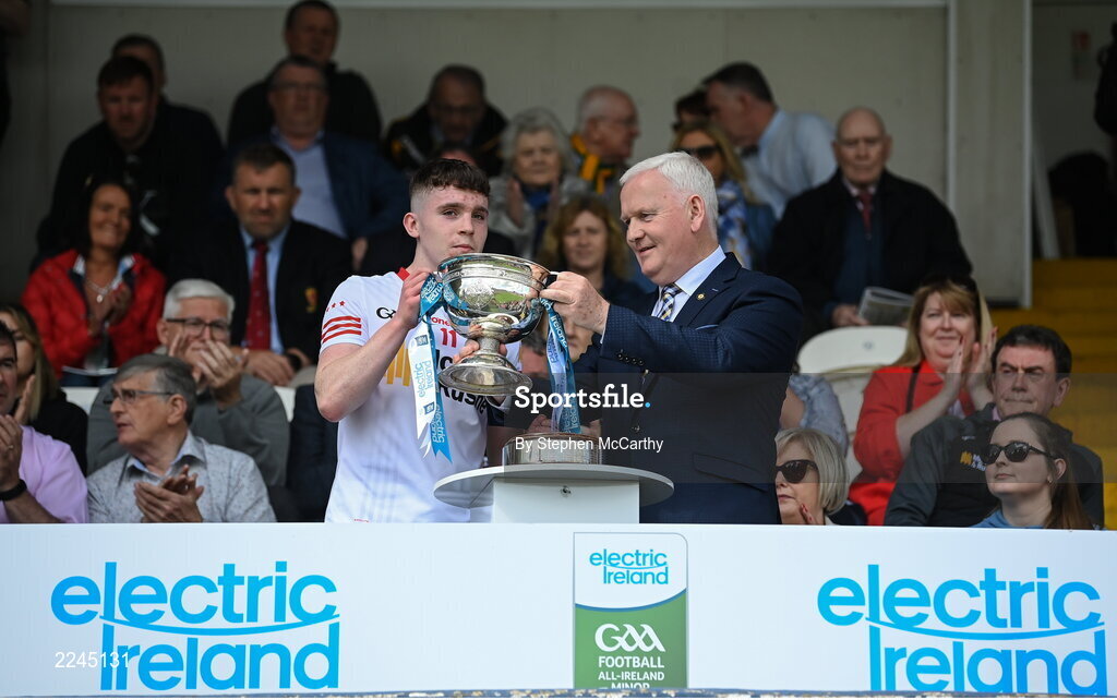 29 May 2022; Tyrone captain Eoin McElholm is presented with the Fr Murray Cup by Ulster GAA vice-president Michael Geoghegan after the Electric Ireland Ulster GAA Football Minor Championship Final match between Derry and Tyrone at St Tiernach's Park in Clones, Monaghan. Photo by Stephen McCarthy/Sportsfile