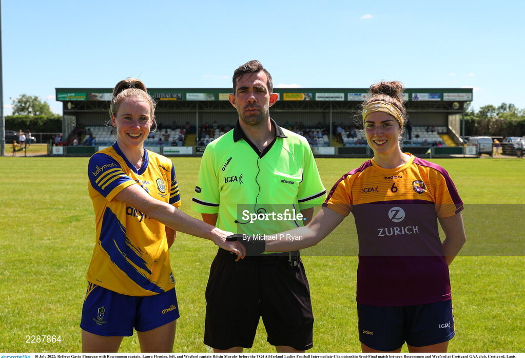 10 July 2022; Referee Gavin Finnegan with Roscommon captain, Laura Fleming, left, and Wexford captain Róisín Murphy before the TG4 All-Ireland Ladies Football Intermediate Championship Semi-Final match between Roscommon and Wexford at Crettyard GAA club, Crettyard, Laois. Photo by Michael P Ryan/Sportsfile