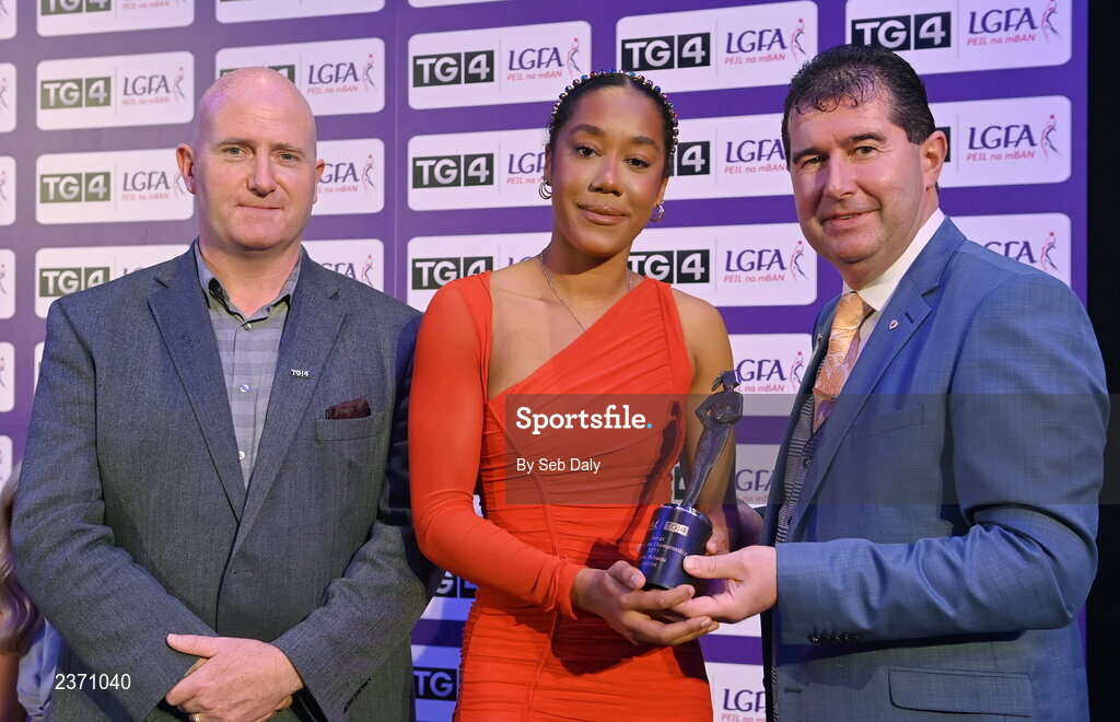 4 November 2022; Lara Dahunsi of Antrim is presented with her TG4 Junior Team of the Championship award by Mícheál Naughton, LGFA President, right, and Rónán Ó Coisdealbha, Head of Sport, TG4, at the 2022 TG4 Teams of the Championship awards night at Croke Park, Dublin. Photo by Seb Daly/Sportsfile
