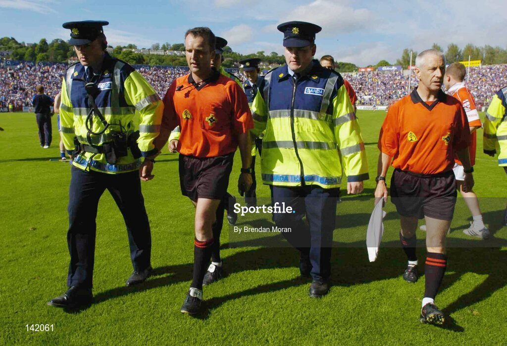 6 June 2004; Referee Diarmuid Kirwan, centre, and his linesmen are escorted from the pitch after the game by Gardai. Guinness Munster Senior Hurling Championship Semi-Final, Tipperary v Waterford, Pairc Ui Chaoimh, Cork. Picture credit; Brendan Moran / SPORTSFILE