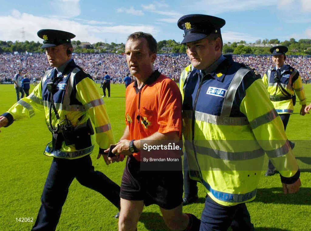 6 June 2004; Referee Diarmuid Kirwan is escorted off the pitch at the end of the game by Gardai. Guinness Munster Senior Hurling Championship Semi-Final, Tipperary v Waterford, Pairc Ui Chaoimh, Cork. Picture credit; Brendan Moran / SPORTSFILE