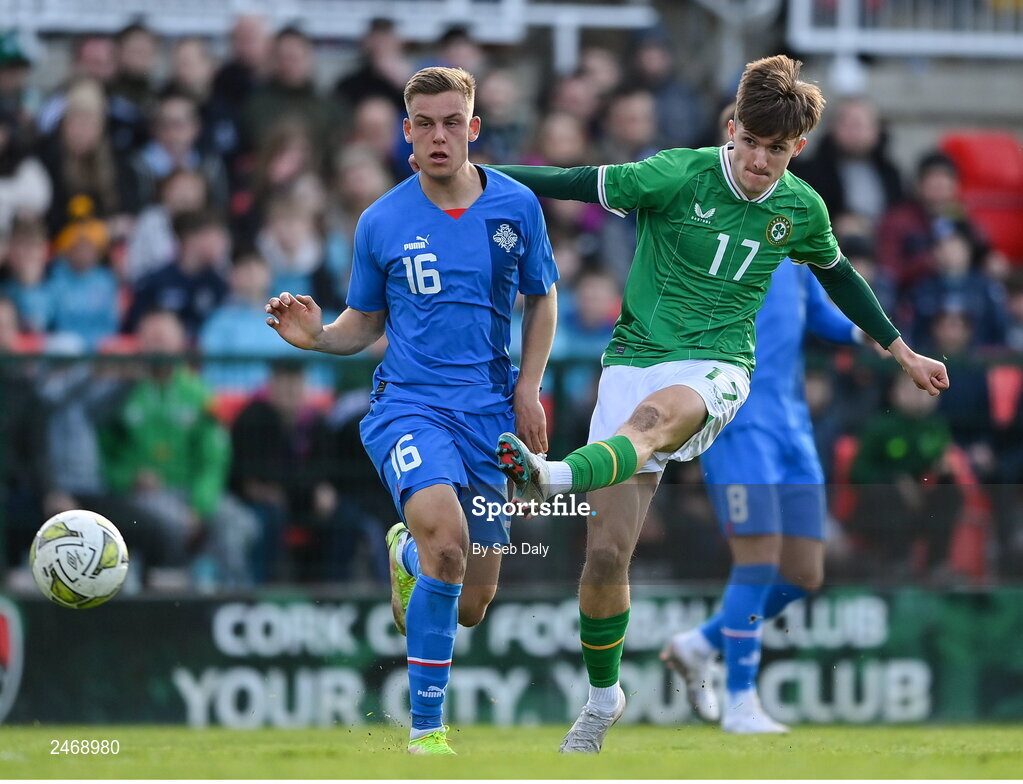 26 March 2023; Johnny Kenny of Republic of Ireland scores his side's second goal, despite pressure from Iceland's Kristofer Jonsson, during the Under-21 international friendly match between Republic of Ireland and Iceland at Turners Cross in Cork. Photo by Seb Daly/Sportsfile