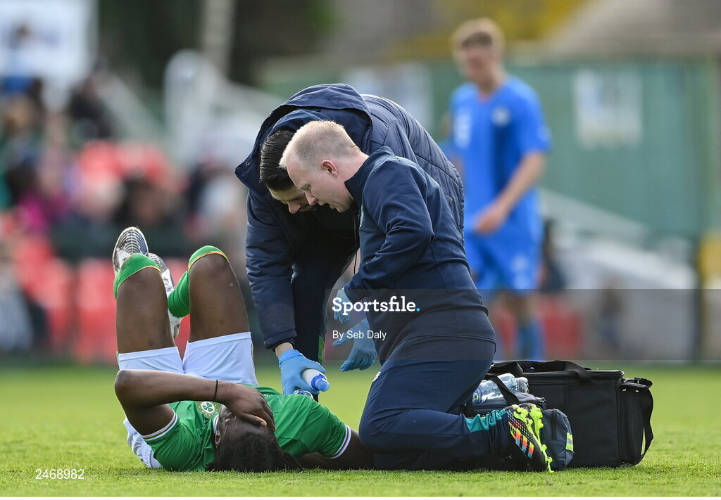 26 March 2023; Republic of Ireland team doctor Dr Mortimer O'Connor, right, and physiotherapist Glauber Barduzzi tend to Bosun Lawal during the Under-21 international friendly match between Republic of Ireland and Iceland at Turners Cross in Cork. Photo by Seb Daly/Sportsfile