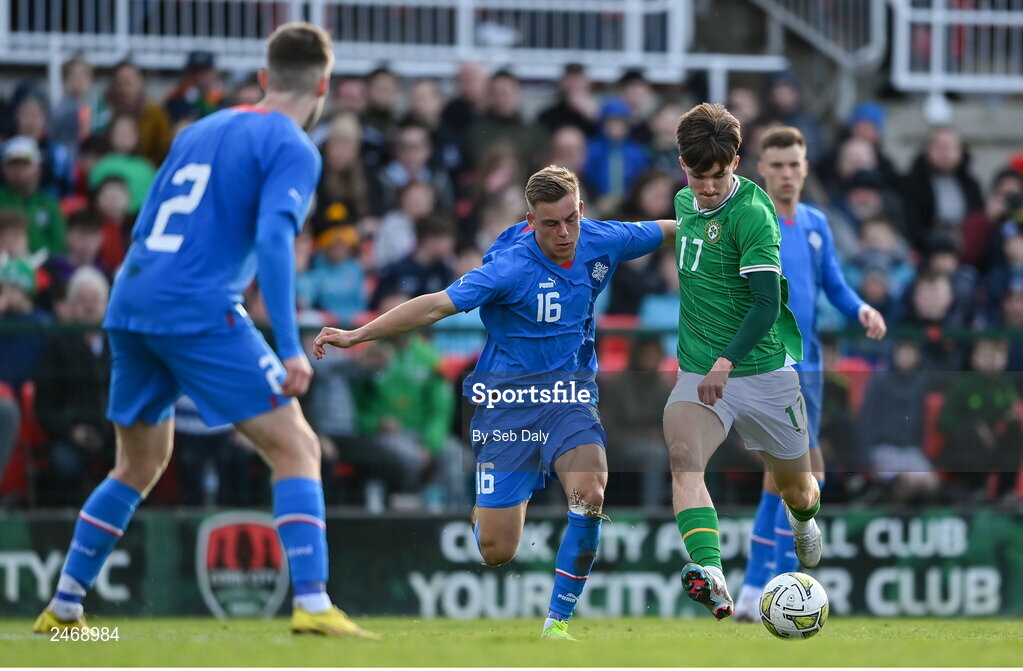 26 March 2023; Johnny Kenny of Republic of Ireland scores his side's second goal, despite pressure from Iceland's Kristofer Jonsson, during the Under-21 international friendly match between Republic of Ireland and Iceland at Turners Cross in Cork. Photo by Seb Daly/Sportsfile