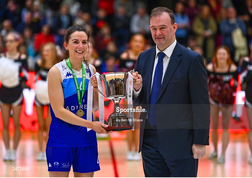 1 April 2023; The Address UCC Glanmire captain Áine McKenna is presented the cup by Basketball Ireland CEO John Feehan after the MissQuote.ie Champions Trophy Final match between The Address UCC Glanmire, Cork and DCU Mercy, Dublin at National Basketball Arena in Tallaght, Dublin. Photo by Ben McShane/Sportsfile