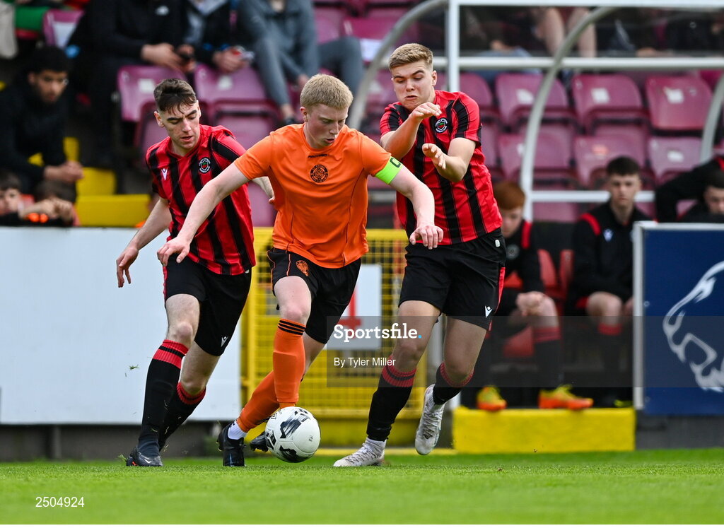 6 May 2023; Logan O'Connell of St Kevin's FC in action against Sean McLnerney of Cherry Orchard FC, left, and Sam Dunne during the FAI Under 17 Cup Final 2022/23 match between Cherry Orchard FC and St Kevin’s Boys FC at Richmond Park in Dublin. Photo by Tyler Miller/Sportsfile