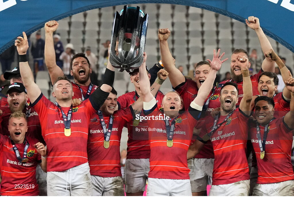 27 May 2023; Munster captain Peter O'Mahony, left, and Keith Earls lift the trophy as teammates celebrate after winning the United Rugby Championship Final match between DHL Stormers and Munster at DHL Stadium in Cape Town, South Africa. Photo by Nic Bothma/Sportsfile