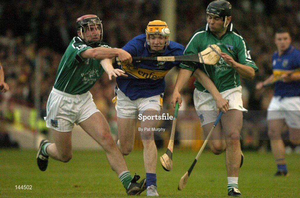 26 June 2004; Lar Corbett, Tipperary, is tackled by Damien Reale, left, and TJ Ryan, Limerick. Guinness Senior Hurling Championship Qualifier, Round 1, Limerick v Tipperary, Gaelic Grounds, Limerick. Picture credit; Pat Murphy / SPORTSFILE