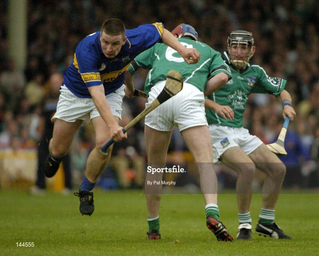 26 June 2004; John Carroll, Tipperary, is tackled by Brian Geary, Limerick. Guinness Senior Hurling Championship Qualifier, Round 1, Limerick v Tipperary, Gaelic Grounds, Limerick. Picture credit; Pat Murphy / SPORTSFILE