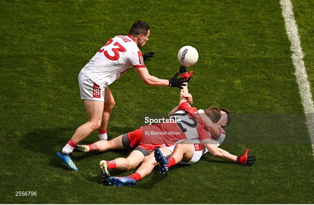 2 July 2023; Daniel O'Mahony of Cork passes the ball to teammate Daniel O'Mahony, left, as he is tackld by Paul McNeil of Derry during the GAA Football All-Ireland Senior Championship quarter-final match between Derry and Cork at Croke Park in Dublin. Photo by Brendan Moran/Sportsfile