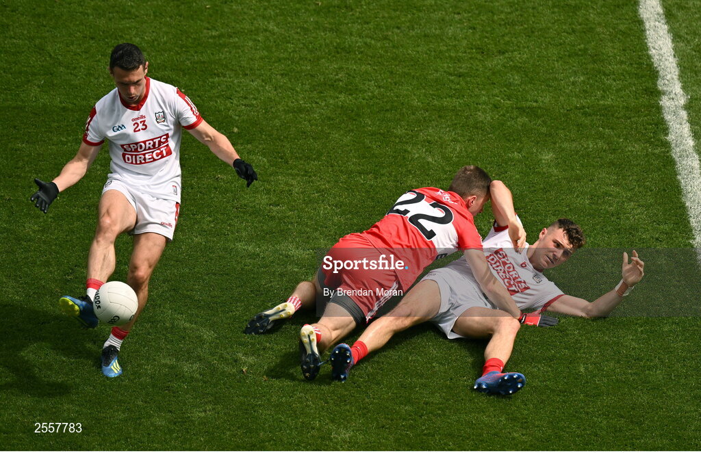 2 July 2023; John O'Rourke of Cork plays the ball as teammate Daniel O'Mahony recovers from a tackle by Paul McNeil of Derry during the GAA Football All-Ireland Senior Championship quarter-final match between Derry and Cork at Croke Park in Dublin. Photo by Brendan Moran/Sportsfile