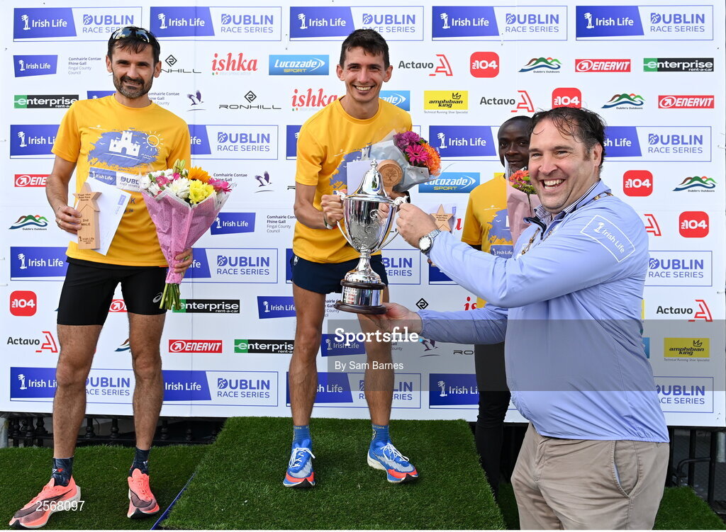 16 July 2023; Emmet Jennings of Dundrum South Dublin AC, centre, is presented with the cup by Mayor of Fingal, Councillor Adrian Henchy, after winning the men's race during the 2023 Irish Life Dublin Race Series-Fingal 10km which took place on Sunday 16th of July at Swords in Dublin. Photo by Sam Barnes/Sportsfile