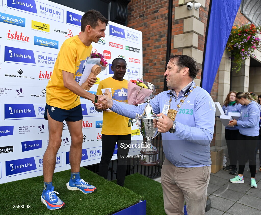 16 July 2023; Emmet Jennings of Dundrum South Dublin AC, is presented with the cup by Mayor of Fingal, Councillor Adrian Henchy, after winning the men's race during the 2023 Irish Life Dublin Race Series-Fingal 10km which took place on Sunday 16th of July at Swords in Dublin. Photo by Sam Barnes/Sportsfile