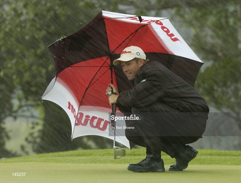 2 July 2004; Padraig Harrington takes cover from the rain on 9th green during the Smurfit European Open. South Course, K Club, Straffan, Co. Kildare, Ireland. Picture credit; Matt Browne / SPORTSFILE