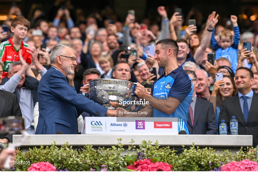 30 July 2023; Dublin captain James McCarthy is presented with the Sam Maguire cup by Uachtarán Chumann Lúthchleas Gael Larry McCarthy after the GAA Football All-Ireland Senior Championship final match between Dublin and Kerry at Croke Park in Dublin. Photo by Ramsey Cardy/Sportsfile