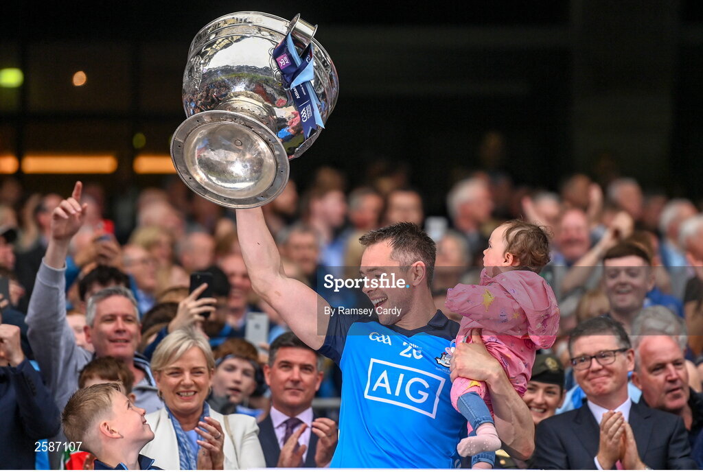 30 July 2023; Dean Rock of Dublin, with his daughter Sadie, lifts the Sam Maguire Cup after the GAA Football All-Ireland Senior Championship final match between Dublin and Kerry at Croke Park in Dublin. Photo by Ramsey Cardy/Sportsfile