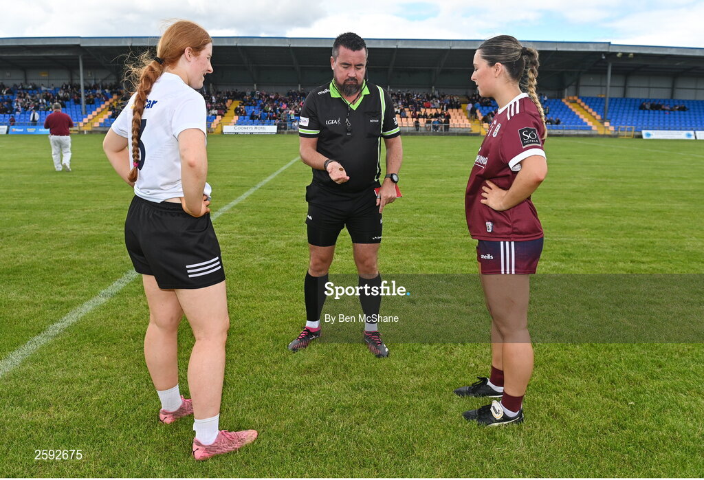 5 August 2023; Referee Seamus Mulvihill performs the coin-toss with team captains Eimear Glancy of Kildare and Aoibhinn Eilian of Galway before the ZuCar All-Ireland Ladies Football U18 A final match between Galway and Kildare at Glennon Brothers Pearse Park in Longford. Photo by Ben McShane/Sportsfile