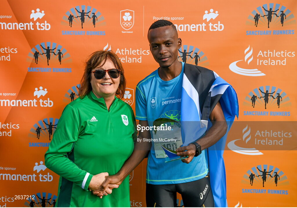 1 October 2023; Kahumburuka Ivan Tuahuku, originally from Botswana, is presented with the winners trophy by Catherine Tiernan, Olympic Federation of Ireland commercial director, after winning the Permanent TSB Sanctuary Run 2023 at the Cross Country track of the Sport Ireland Campus in Dublin. The Permanent TSB Sanctuary Run on the Sport Ireland campus attracted nearly 1,000 participants including refugees from Direct Provision centres across Ireland, Ukrainian people in Dublin, locals and Irish Olympians. The event, to celebrate diversity and interculturalism in Ireland today, was run by the Sanctuary Runners’ organisation and supported by the Olympic Federation of Ireland and Athletics Ireland. Photo by Stephen McCarthy/Sportsfile