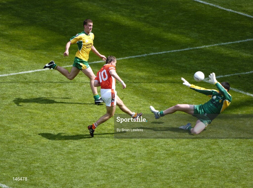 11 July 2004; Armagh's Paddy McKeever shoots past Donegal's Paul Durcan to score his sides second goal as Eamon McGee looks on. Bank of Ireland Ulster Senior Football Championship Final, Armagh v Donegal, Croke Park, Dublin. Picture credit; Brian Lawless / SPORTSFILE