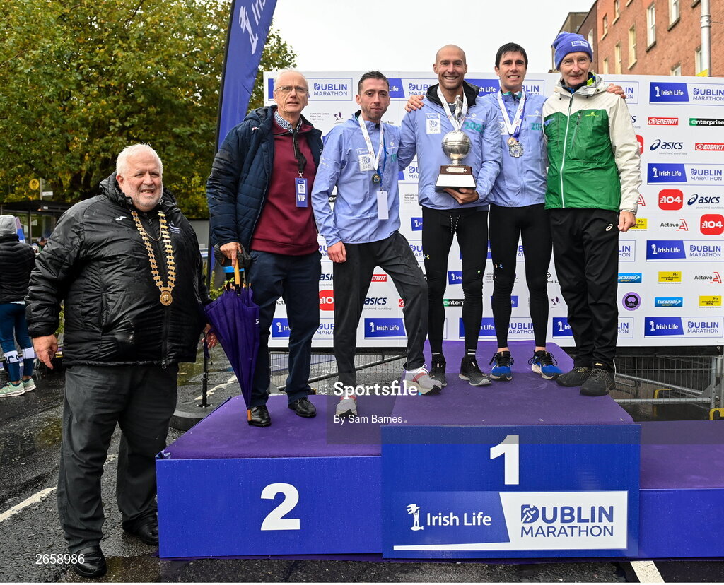 29 October 2023; Pictured, from left, at the Men's National Championship podium, Athletics Ireland President John Cronin, Irish Sports Council Chief Executive and Olympian John Treacy, second place Ryan Creech from Cork, first place Stephen Scullion, third place Ryan Forsyth from Tipperary, and Race Director Jim Aughney after the 2023 Irish Life Dublin Marathon. Thousands of runners took to the Fitzwilliam Square start line, to participate in the 42nd running of the Dublin Marathon. Photo by Sam Barnes/Sportsfile *** NO REPRODUCTION FEE ***