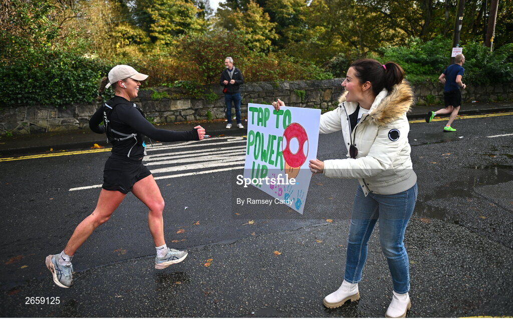 29 October 2023; Megan Reynolds, from Chapelizod, Dublin, holds out a sign for participants during the 2023 Irish Life Dublin Marathon. Thousands of runners took to the Fitzwilliam Square start line, to participate in the 42nd running of the Dublin Marathon. Photo by Ramsey Cardy/Sportsfile