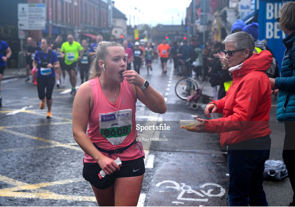 29 October 2023; Rachel Stanley from Dublin grabs a few sweets during the 2023 Irish Life Dublin Marathon. Thousands of runners took to the Fitzwilliam Square start line, to participate in the 42nd running of the Dublin Marathon. Photo by Ray McManus/Sportsfile