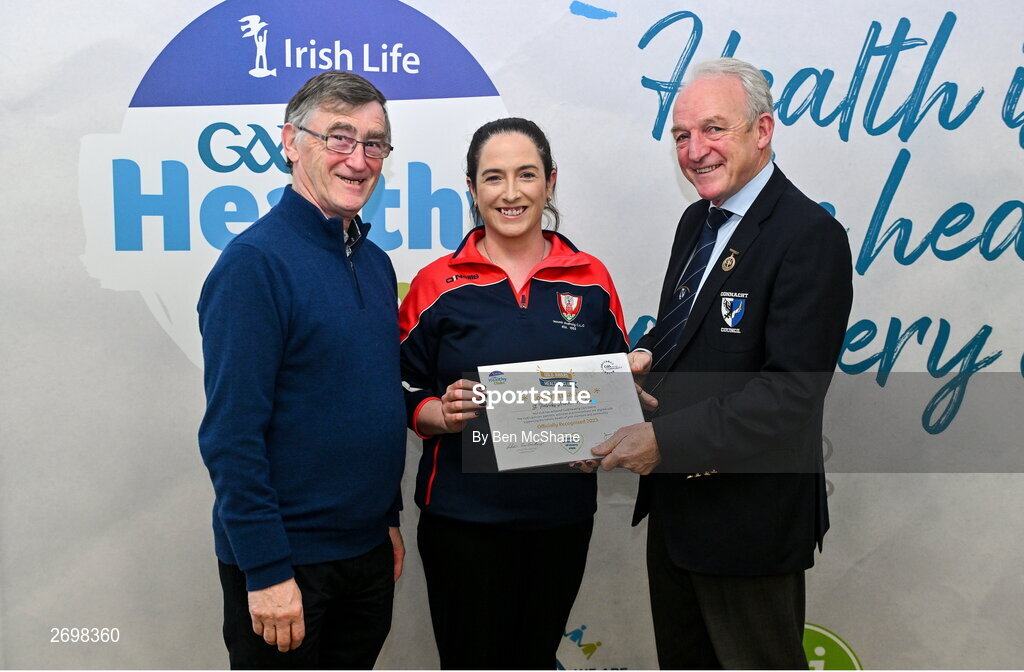 14 December 2023; St Patrick's Drumahair, Leitrim, representative Tracey Kelly is presented their Gold Healthy Club award by Connacht GAA secretary John Prenty, left, and Connacht GAA Council president John Murphy, right, during the Irish Life Connacht GAA Healthy Clubs recognition event at the Connacht GAA Centre of Excellence in Bekan, Mayo. Photo by Ben McShane/Sportsfile
