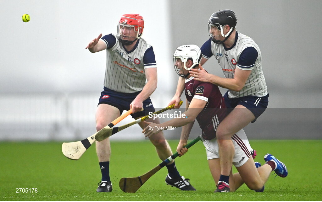 4 January 2024; Tommy Halliday of Galway is tackled by Ger McPartland of New York, left, and Adam Loughlin Stones during the Connacht Hurling League semi-final match between Galway and New York at University of Galway Connacht GAA AirDome in Bekan, Mayo. Photo by Tyler Miller/Sportsfile