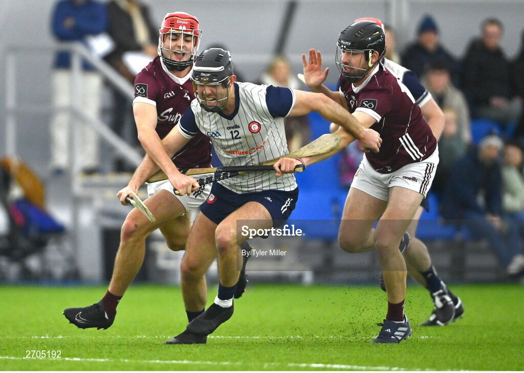 4 January 2024; Martin Cullen of New York is tackled by Fergus Hanney of Galway, left, and Keith Gleeson during the Connacht Hurling League semi-final match between Galway and New York at University of Galway Connacht GAA AirDome in Bekan, Mayo. Photo by Tyler Miller/Sportsfile
